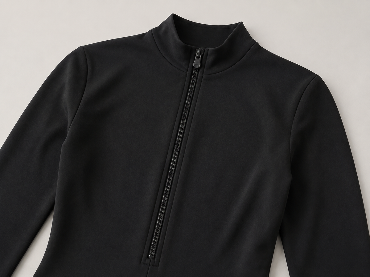 Black unitard mock neck and front zipper detail shown in a product detail view.
