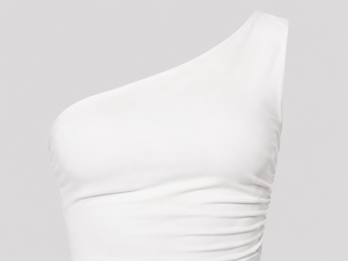 White one-shoulder crop top detail showing the diagonal neckline and gentle front gathering.
