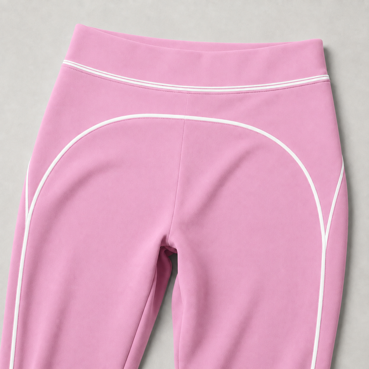 Pink leggings detail showing the high waistband and curved white contrast piping.