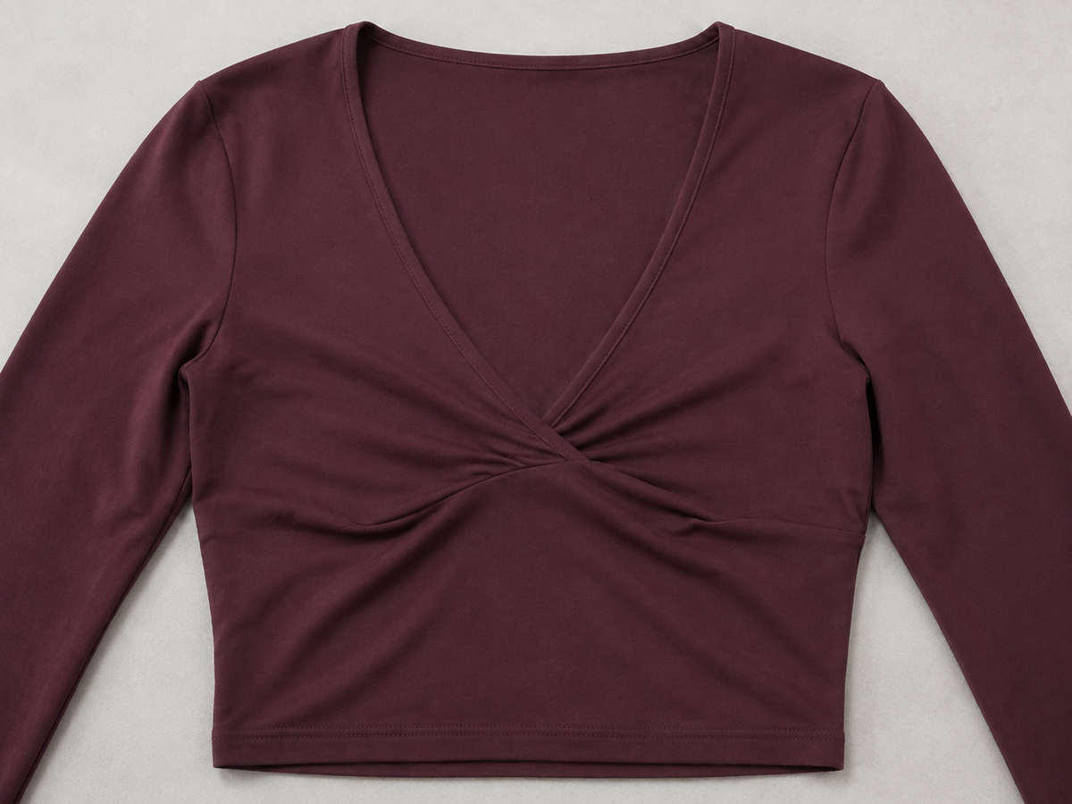 Burgundy long-sleeve crop top detail showing the V-neck and softly gathered crossover front.