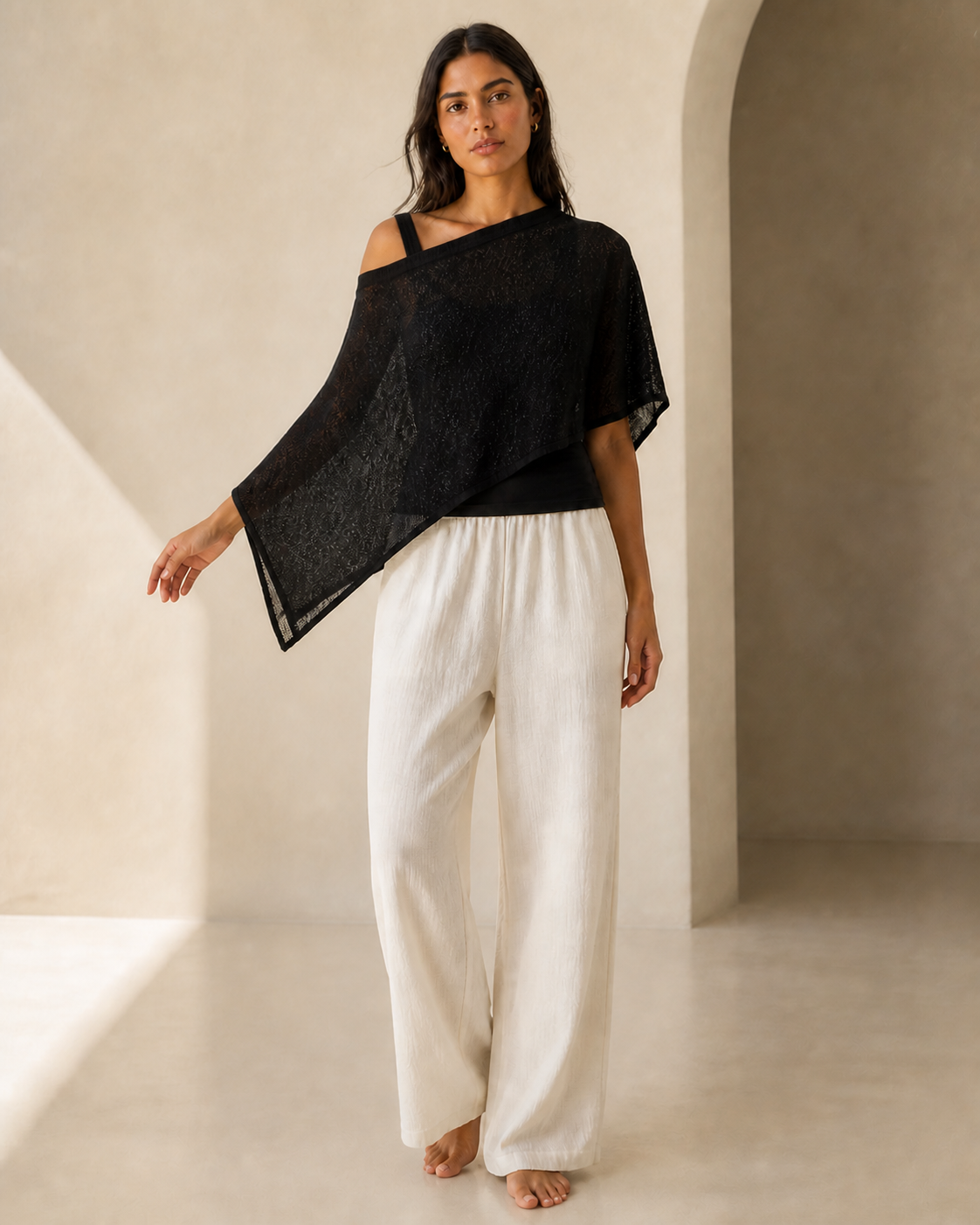 Black knit and sheer batwing poncho, front view on a second model