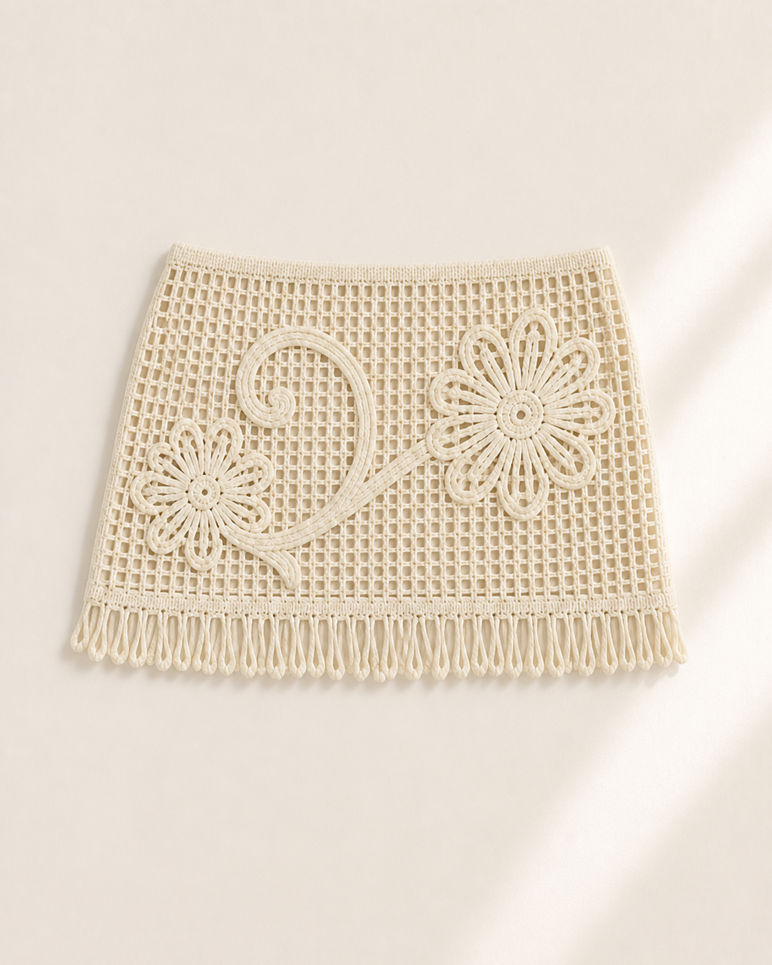 Cream off-white crochet fringe mini skirt with floral vine detail, studio product view