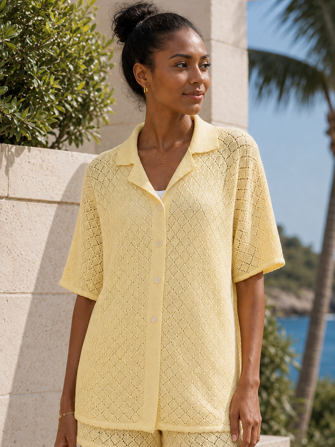 Black model wearing the pale yellow pointelle shirt over a white tank, product-focused view