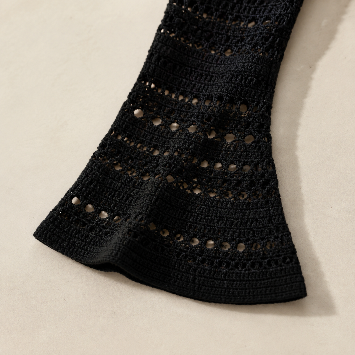Black crochet sleeve detail with horizontal open-knit bands and a gently flared cuff.