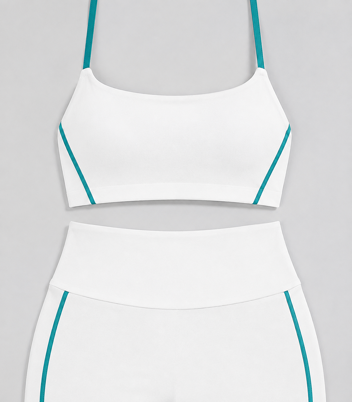 White cami and flare pants detail showing turquoise straps and curved side accents.