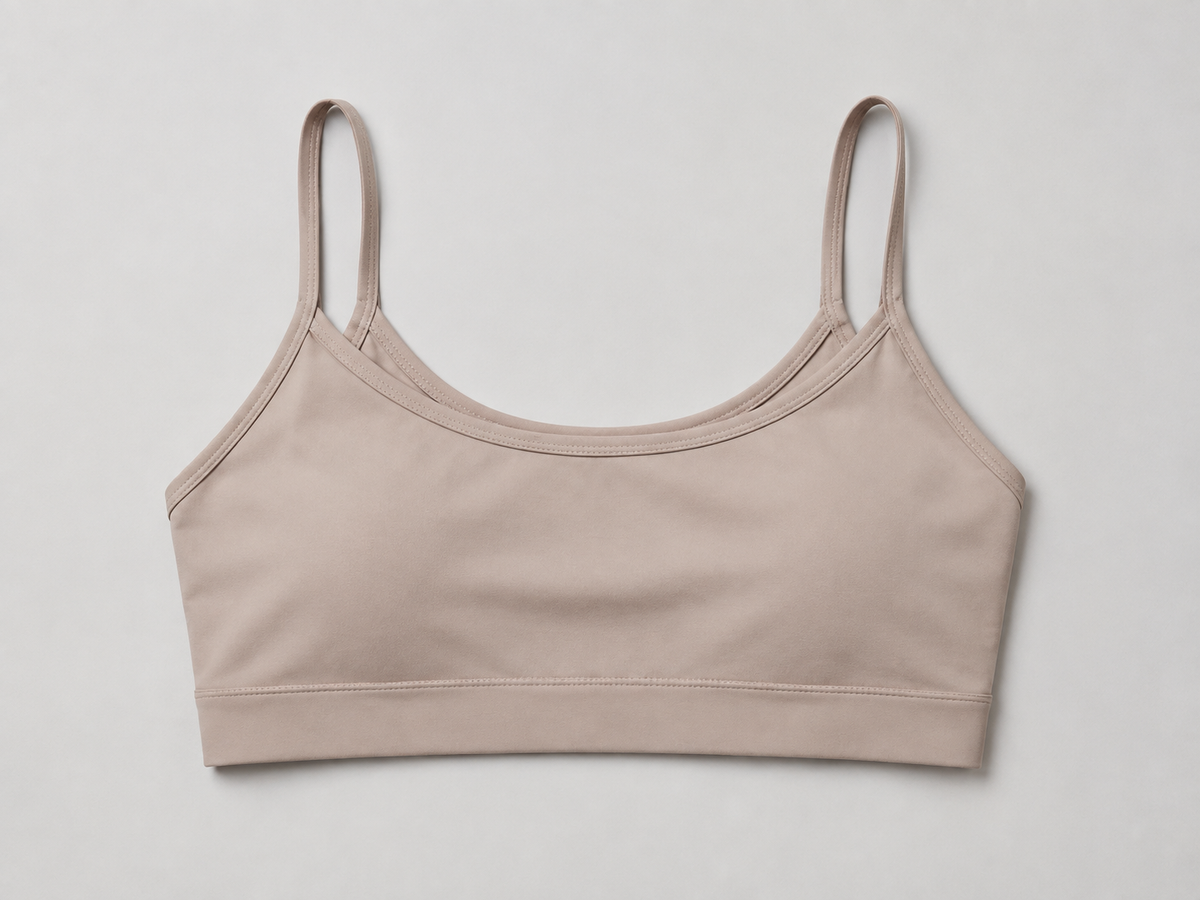 Taupe cami bra detail showing slim straps and a softly scooped neckline.