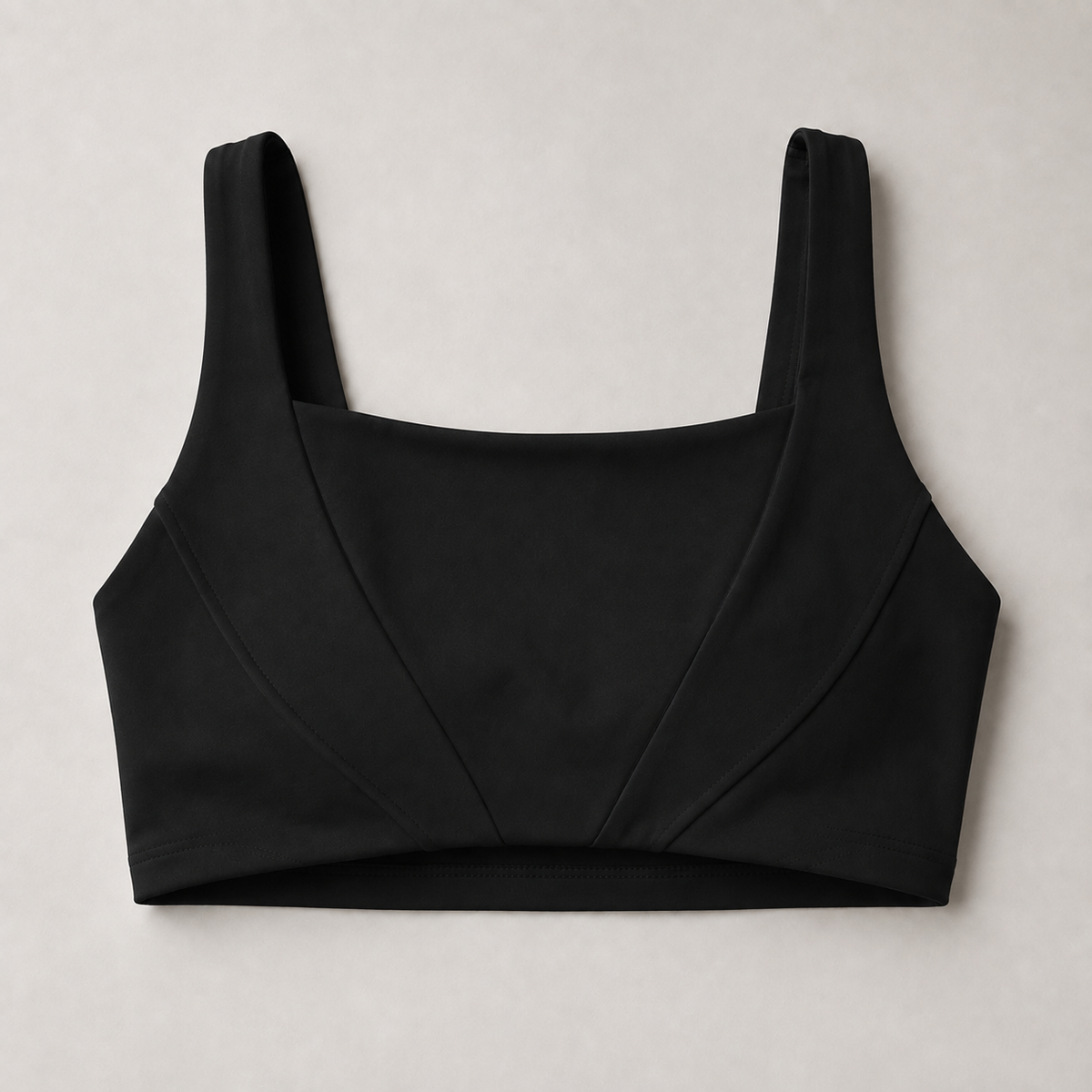 Black square-neck sports bra with wide straps and curved front seam panels.