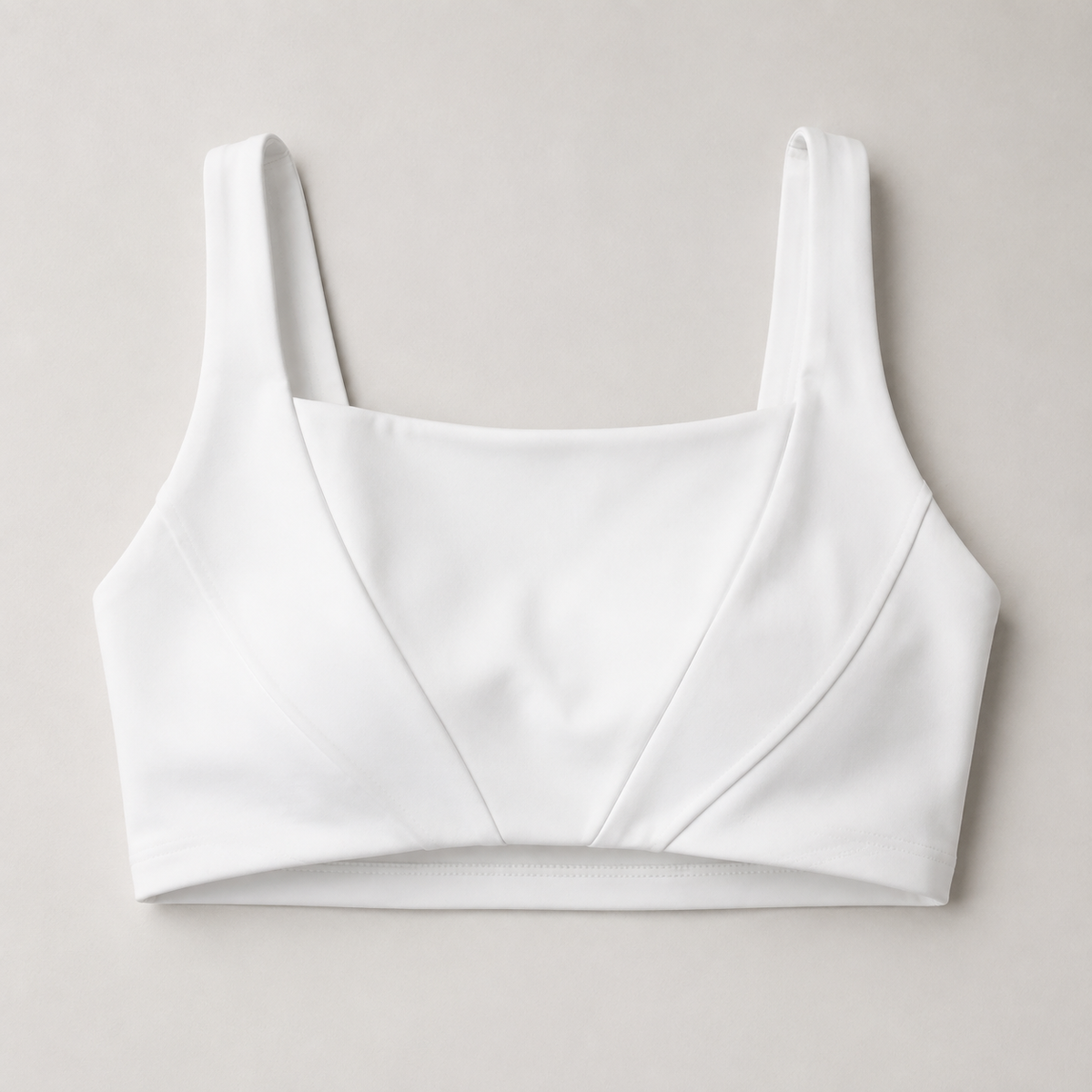 White square-neck sports bra detail showing wide straps and curved front panels.