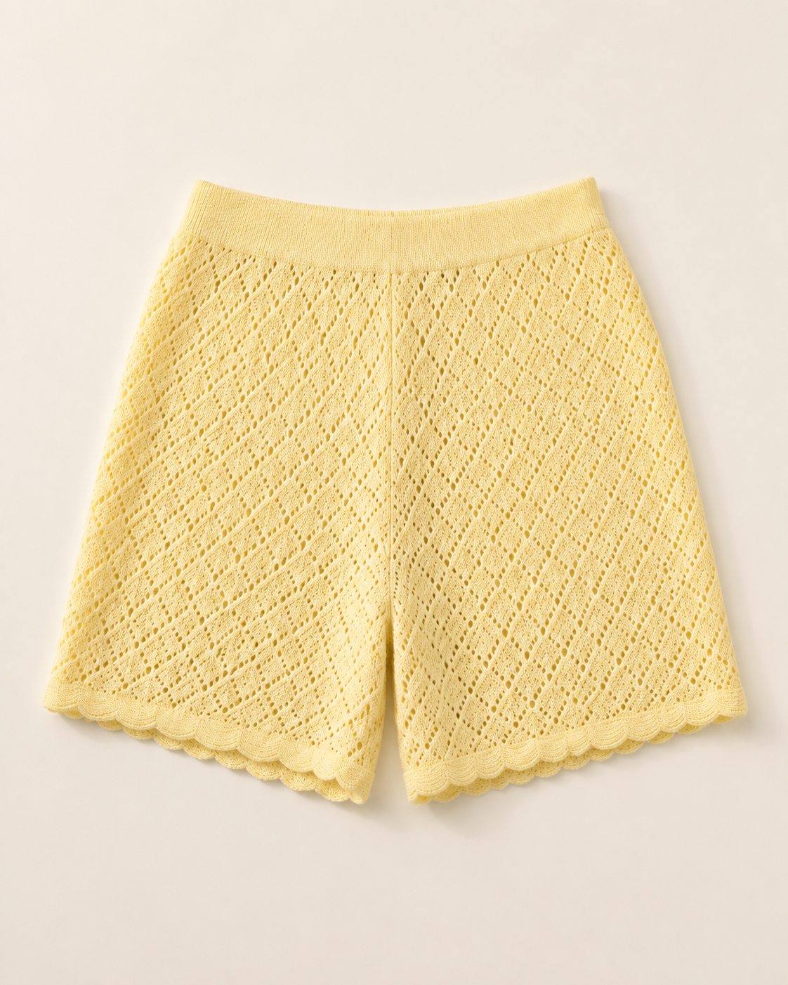 Pale yellow pointelle knit shorts, studio view, full garment shown